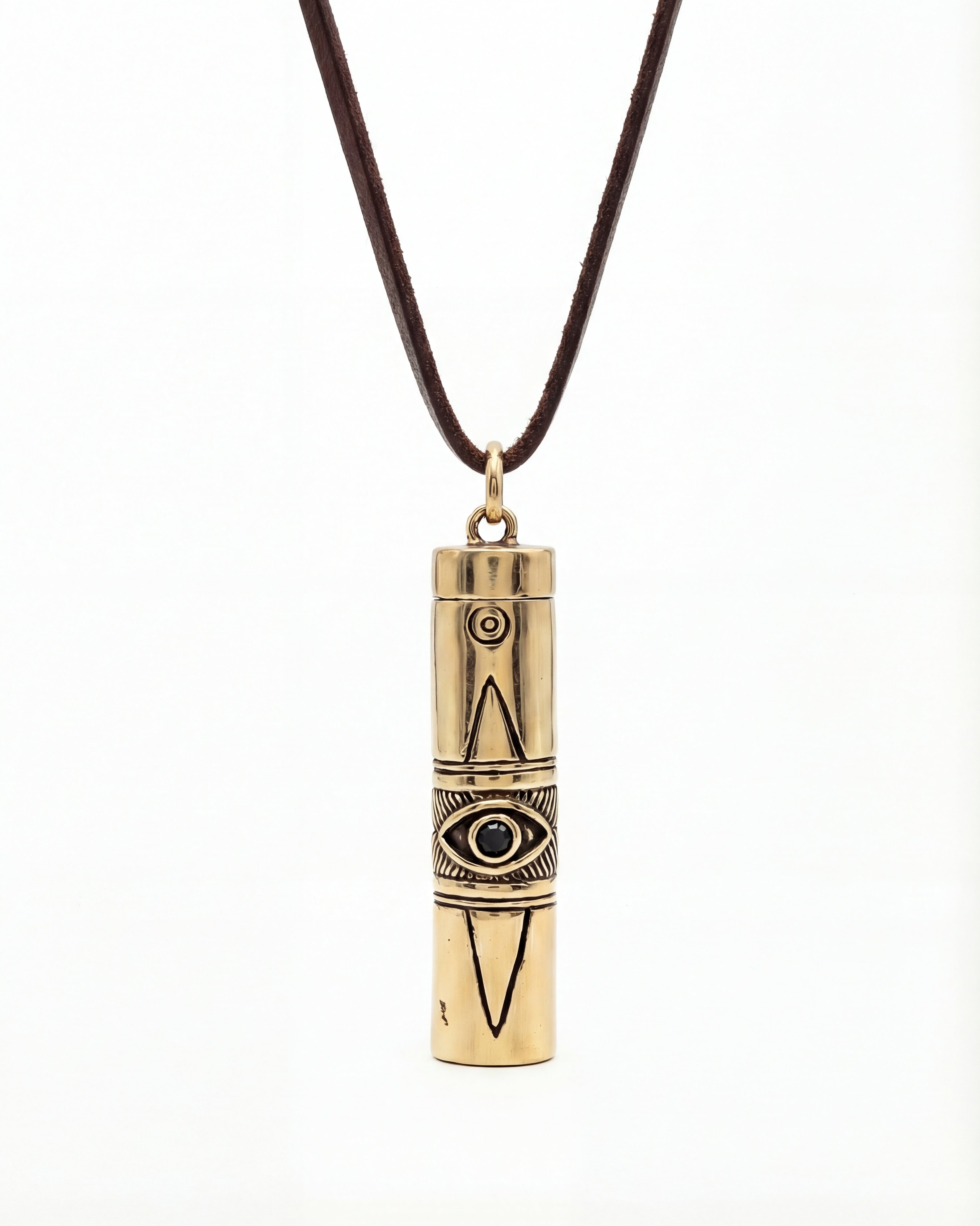 Gold cylindrical pendant with eye design on a brown cord against a white background