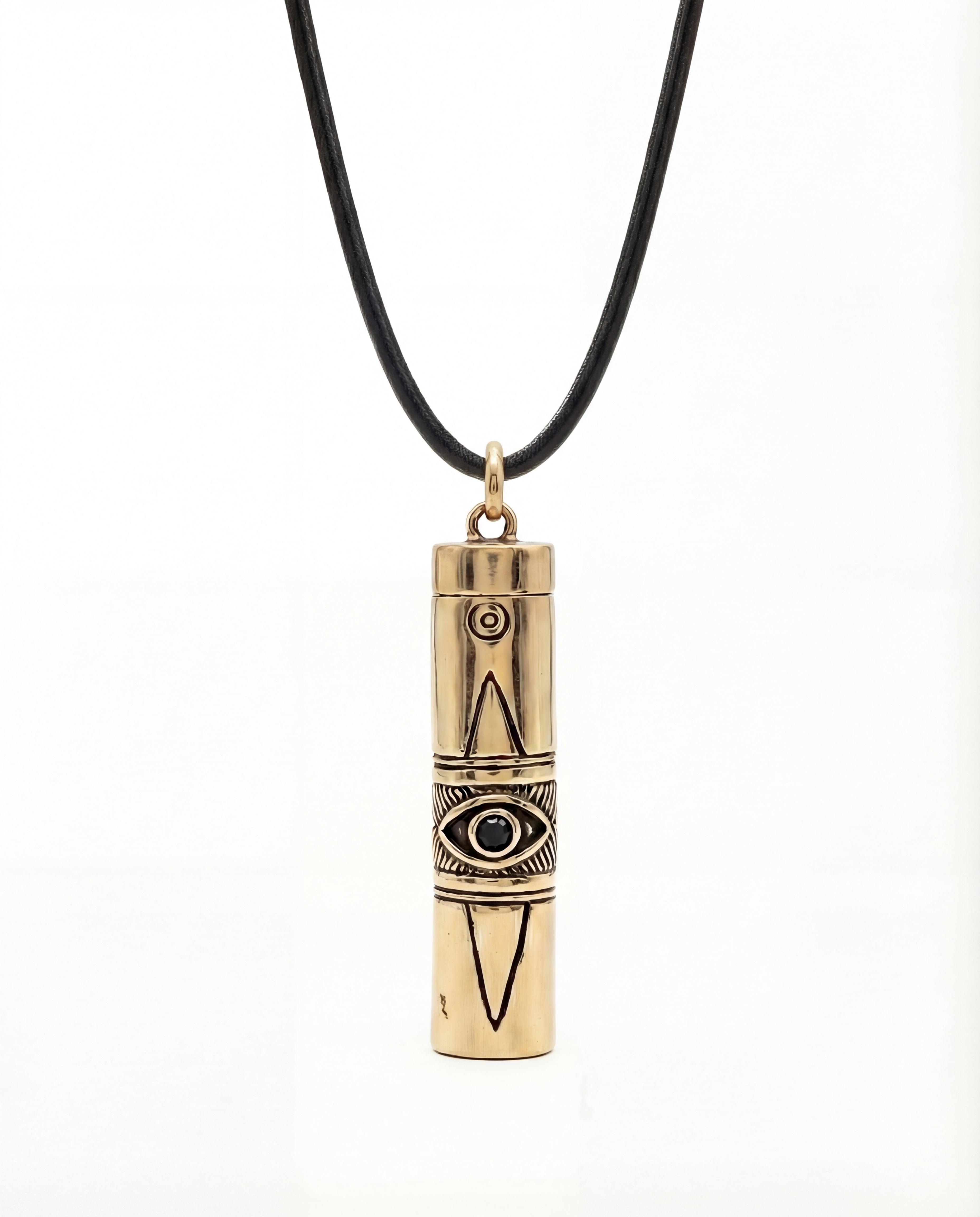 Gold cylindrical pendant with eye design on a black cord against a white background